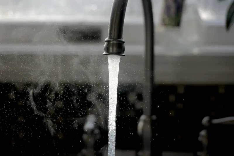 Water running from a faucet into a kitchen sink