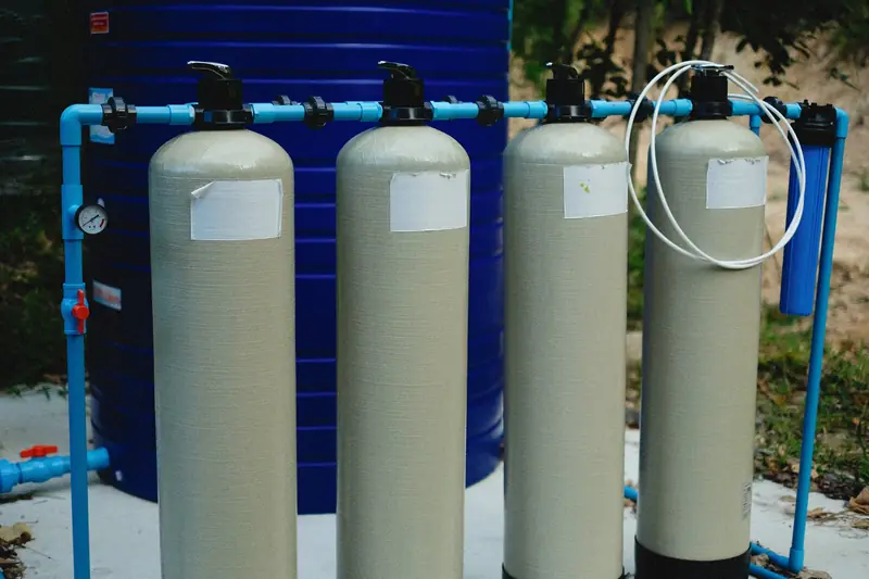 A row of water softener and filter tanks standing side by side